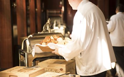 Waiter with basket of bread