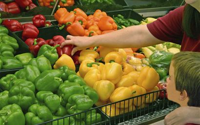 mother  and child selecting red pepper in a a supermarket aisle