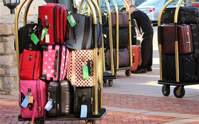luggage and suitcases stacked up on bellman's cart 