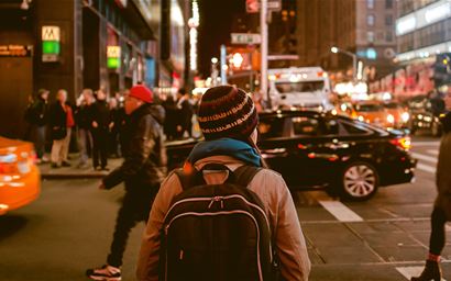 woman with a backpack walking in a city 