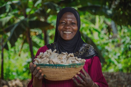 A female farming holding a bowl of crops