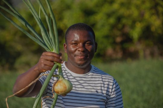 A farmer holding an onion