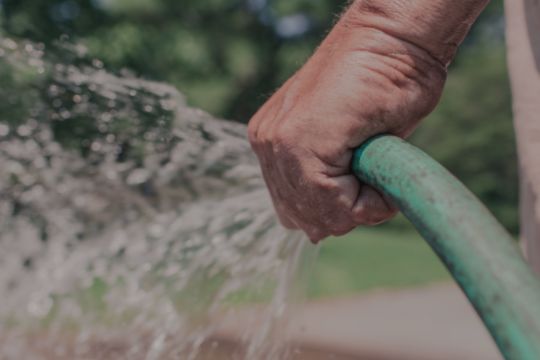 A hand holding a water hose
