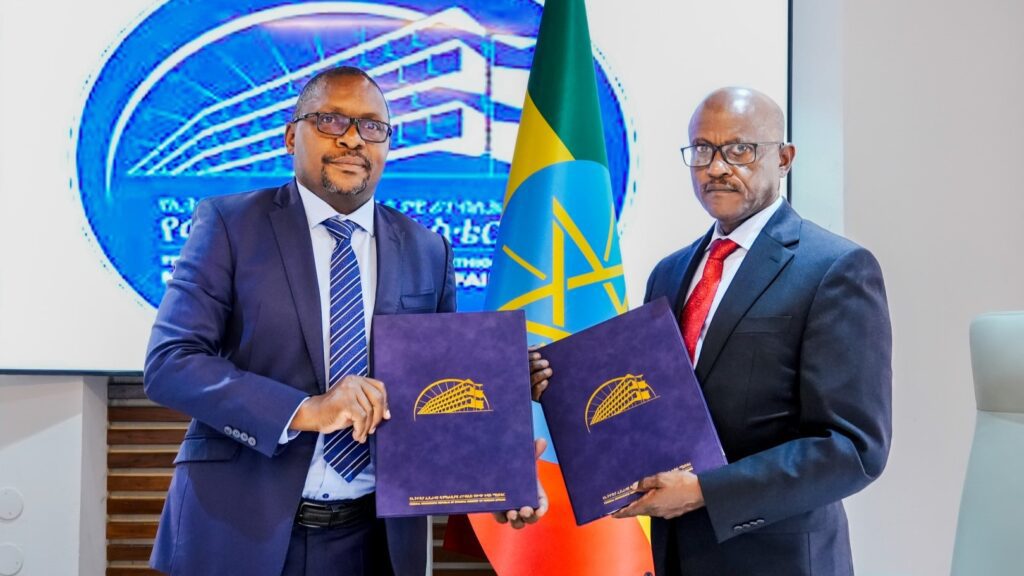 Ambassador Hadera Abera and Dr Morris Akiri hold up the Host Country Agreements after signing.