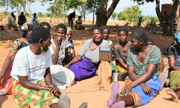 Smallholder farmers gather around a radio in Malawi to hear extension messages on how to grow more profitable crops