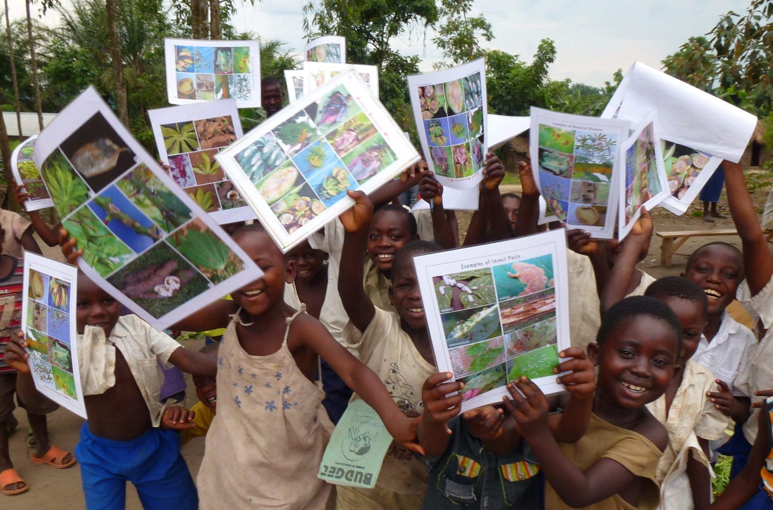 Village children showing poster on invasive pests