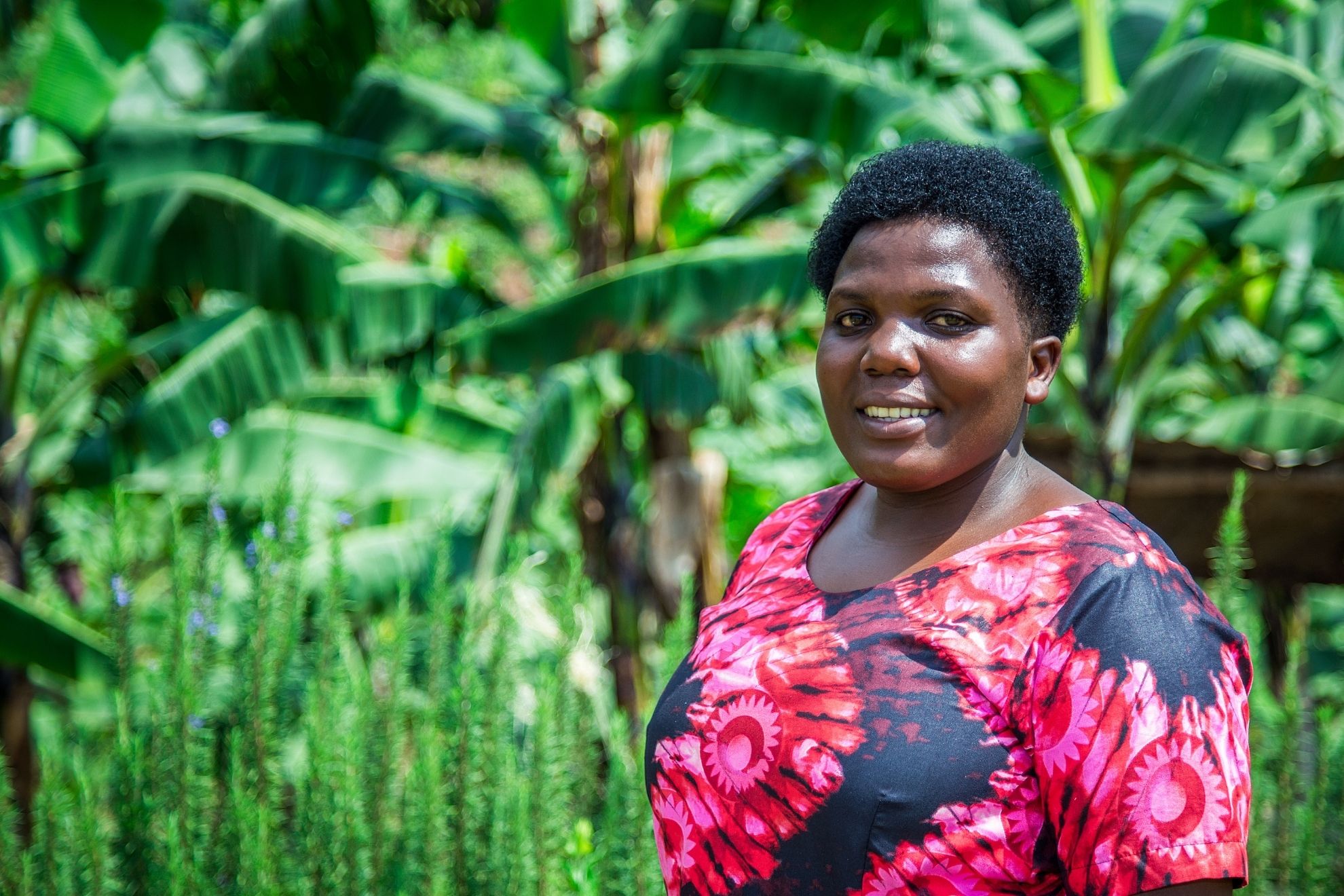 A woman farmer standing in front of her crops