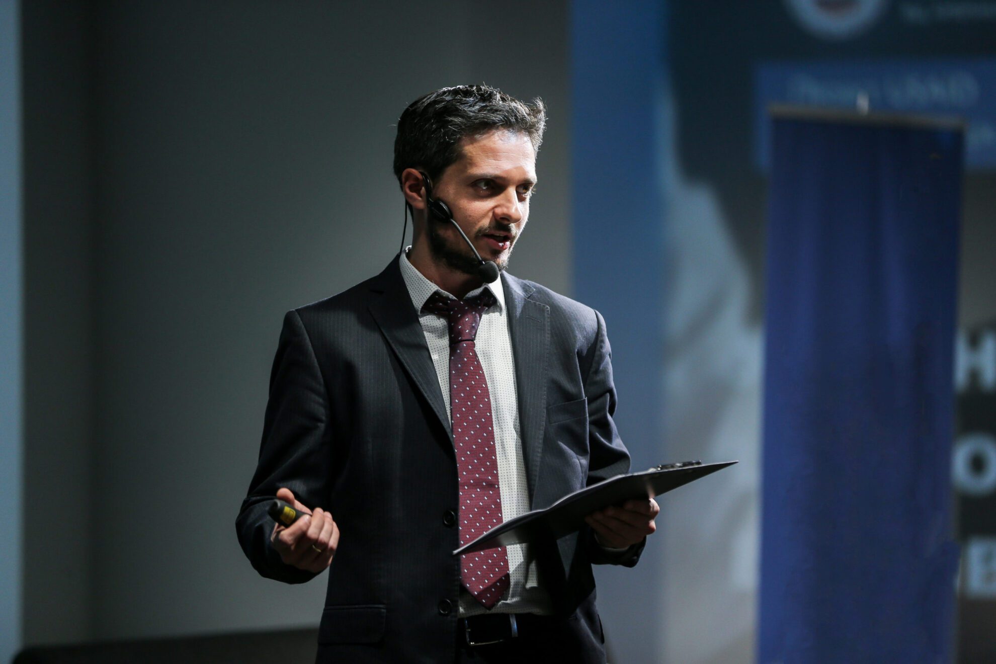 Public speaker giving talk at Business Event Attractive and confident successful man with headset speaking at corporate business coaching and training conference.Business and Entrepreneurship event,motivation training