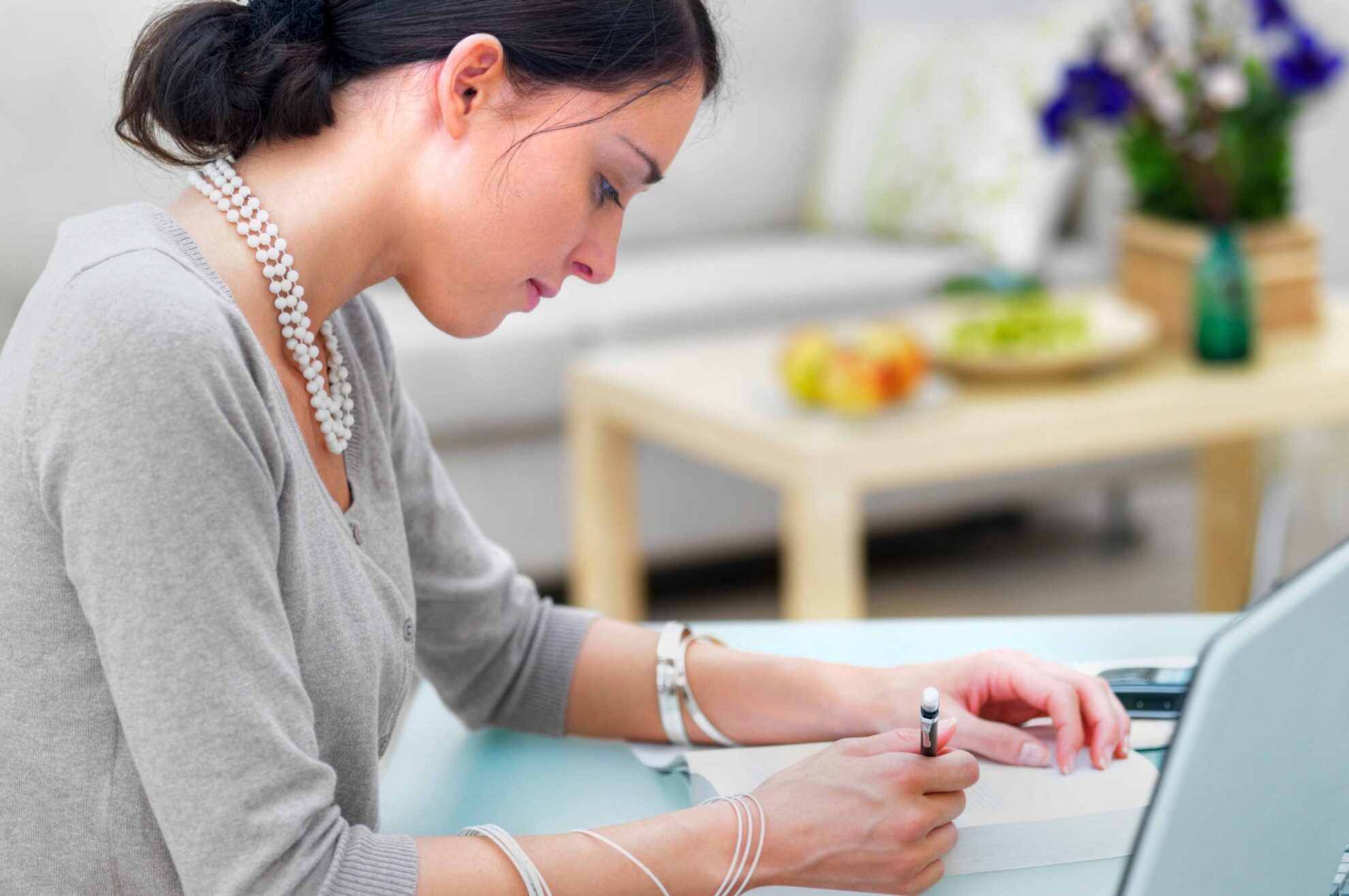 Side profile of a businesswoman writing notes at table Writing Better English