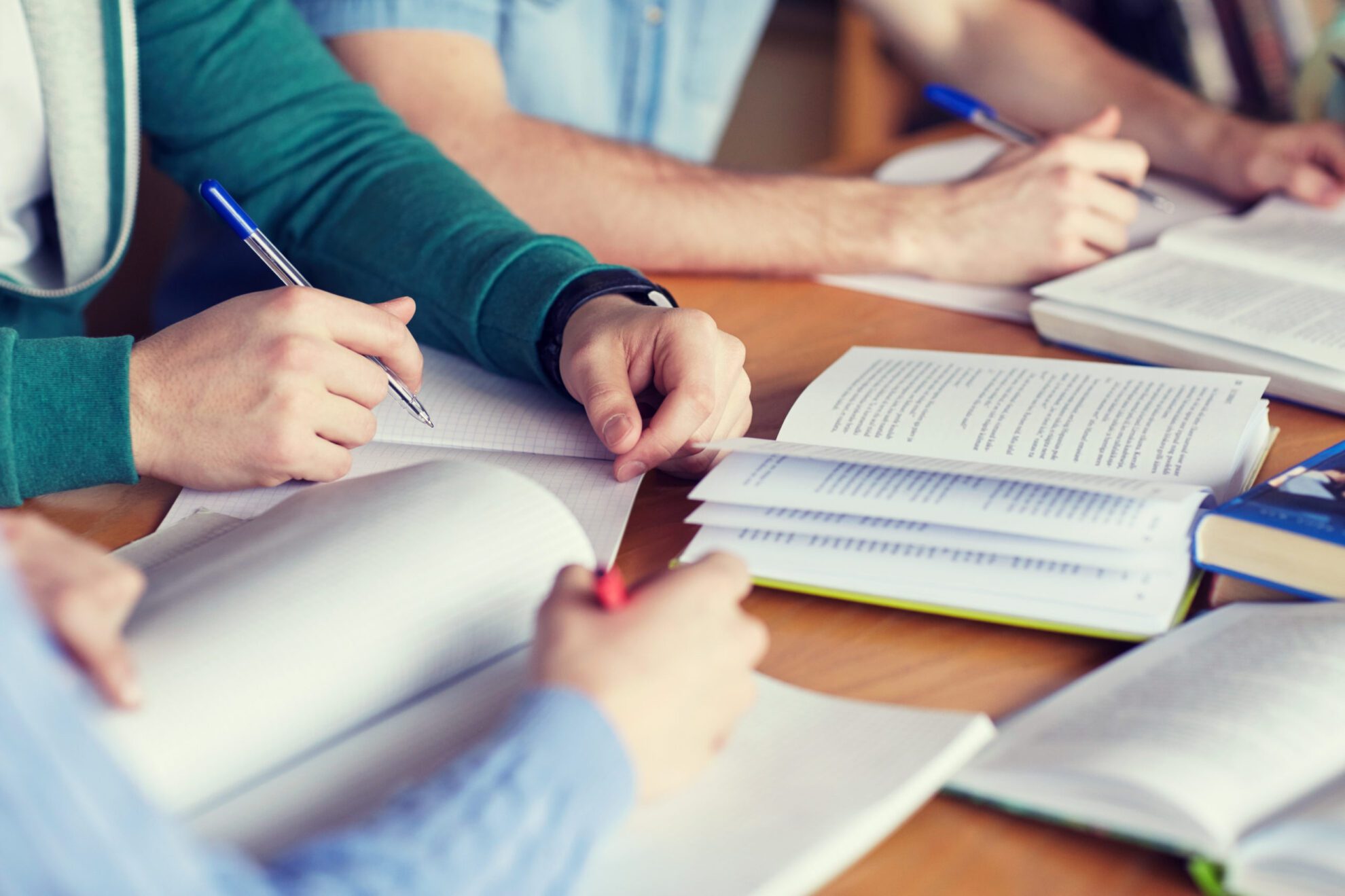 shutterstock_378848479 "People, learning, education and school concept - close up of students hands with books or textbooks writing to notebooks"